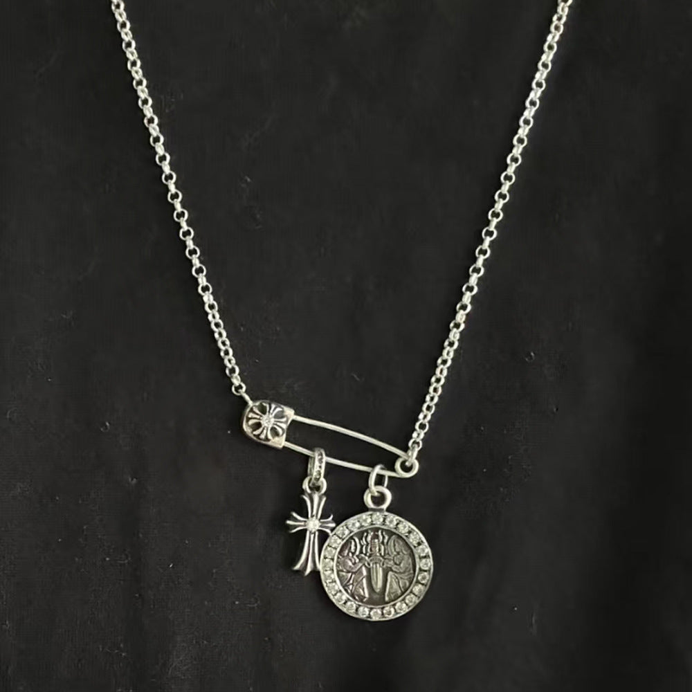 Chrome Hearts brooch with cross and diamond-encrusted round pendant.
