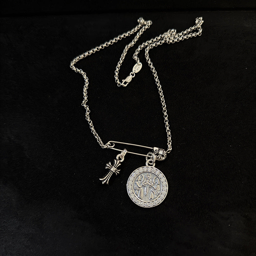 Chrome Hearts brooch with cross and diamond-encrusted round pendant.